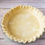 A pie pan with pie crust made with shortening.