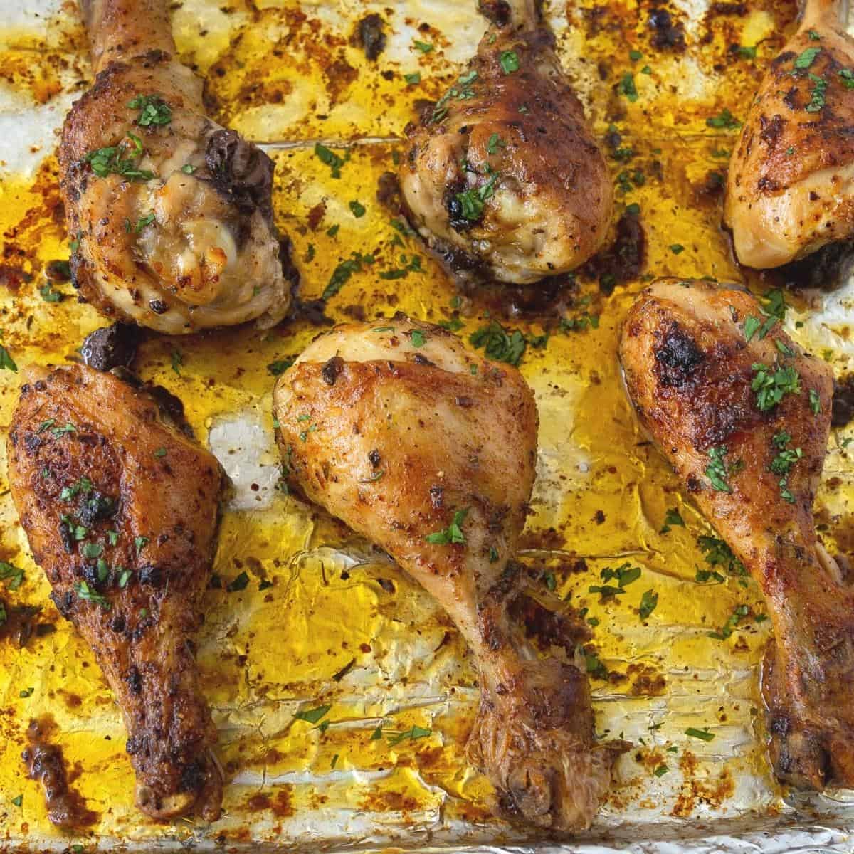 A baking sheet with baked chicken legs.