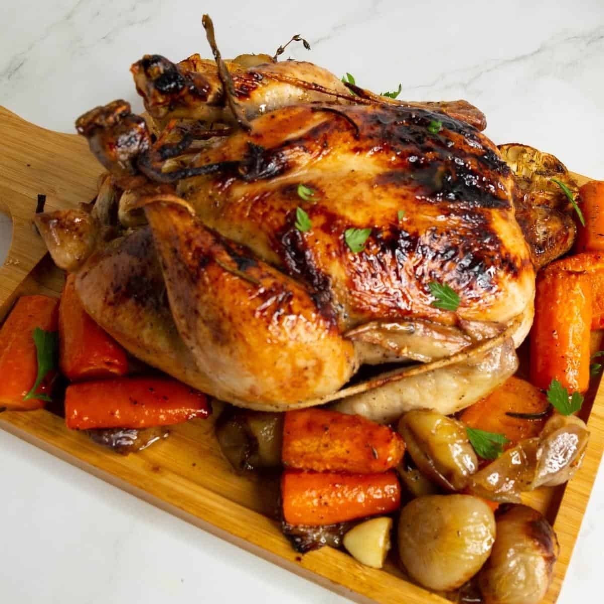 Roast chicken with veggies on a serving platter.