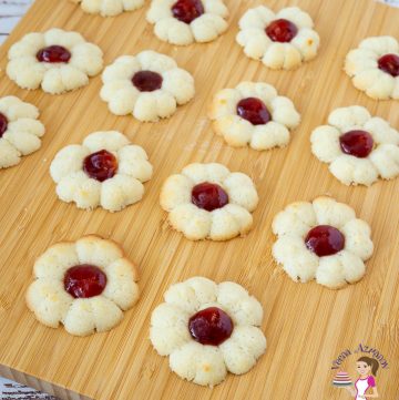 A wooden board with jam spritz cookies