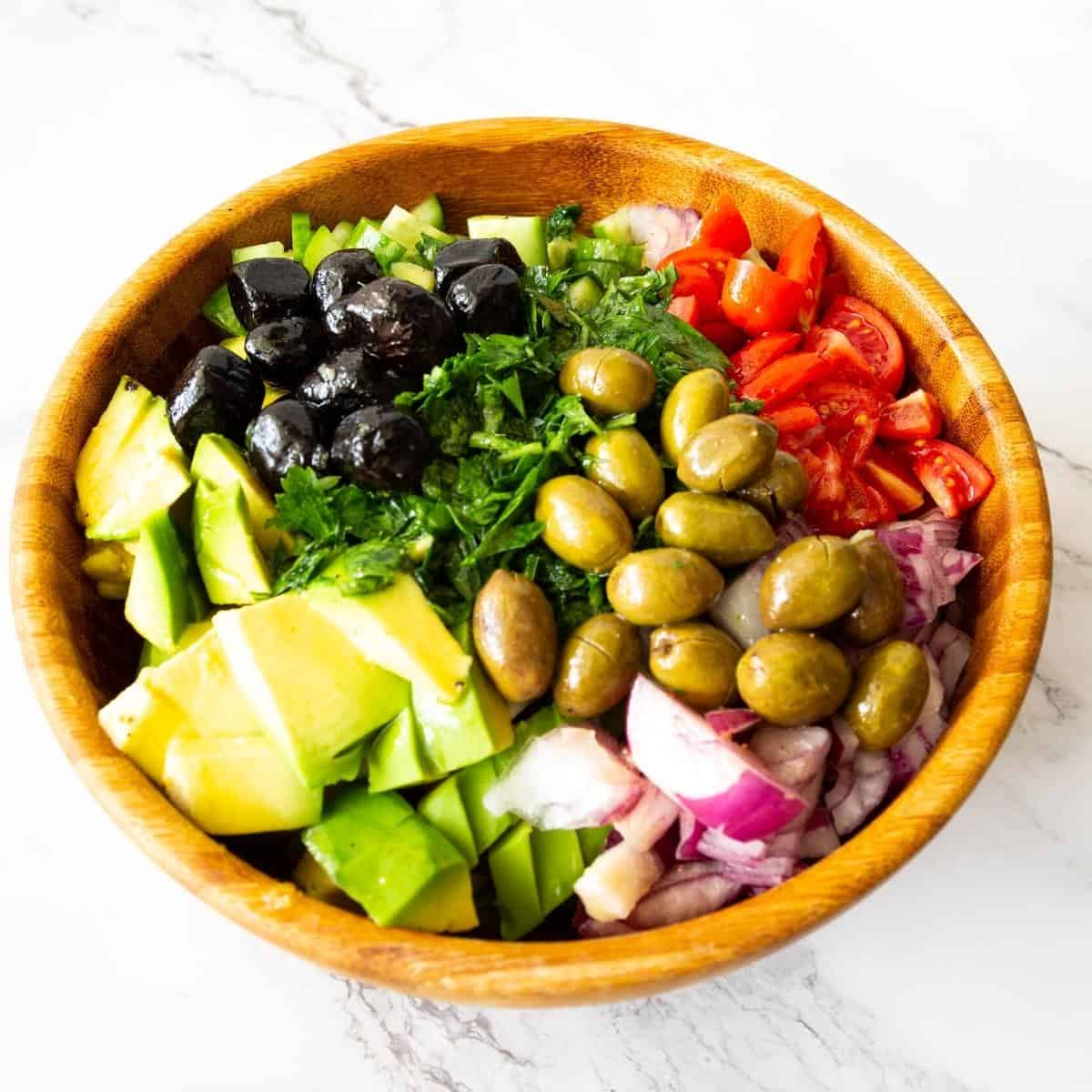 Salad with avocado, olives, cucumber, tomatoes.