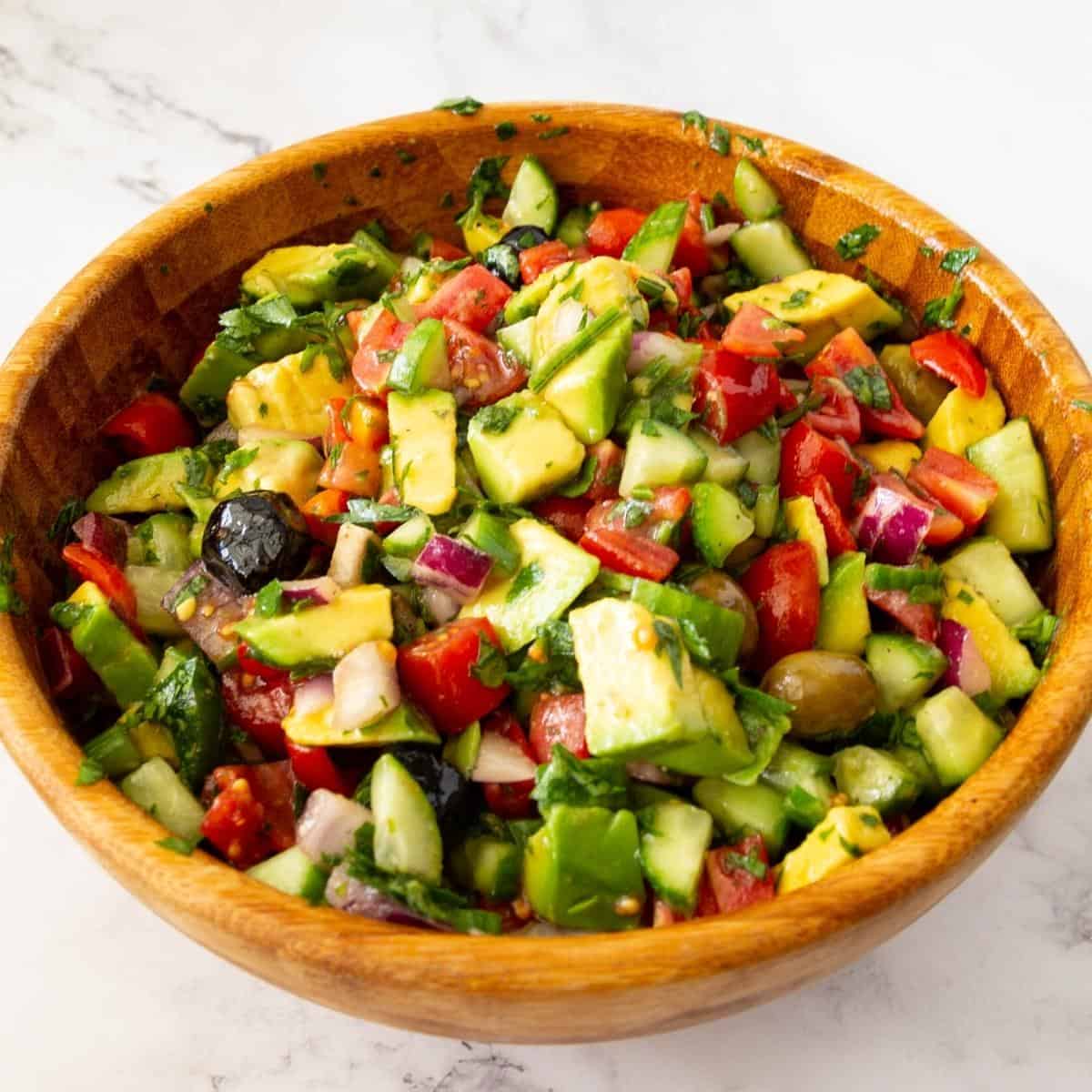 A bowl of salad with avocado and veggies.