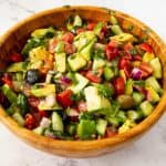 A wooden salad bowl with avocado.