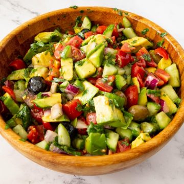 A wooden salad bowl with avocado.