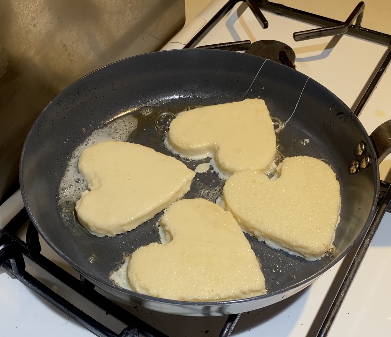 A frying pan with cooking French Toast.