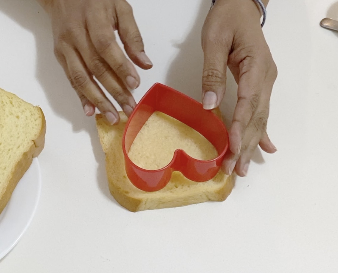 Cutting the Bread Slice with Heart Cookie Cutting.
