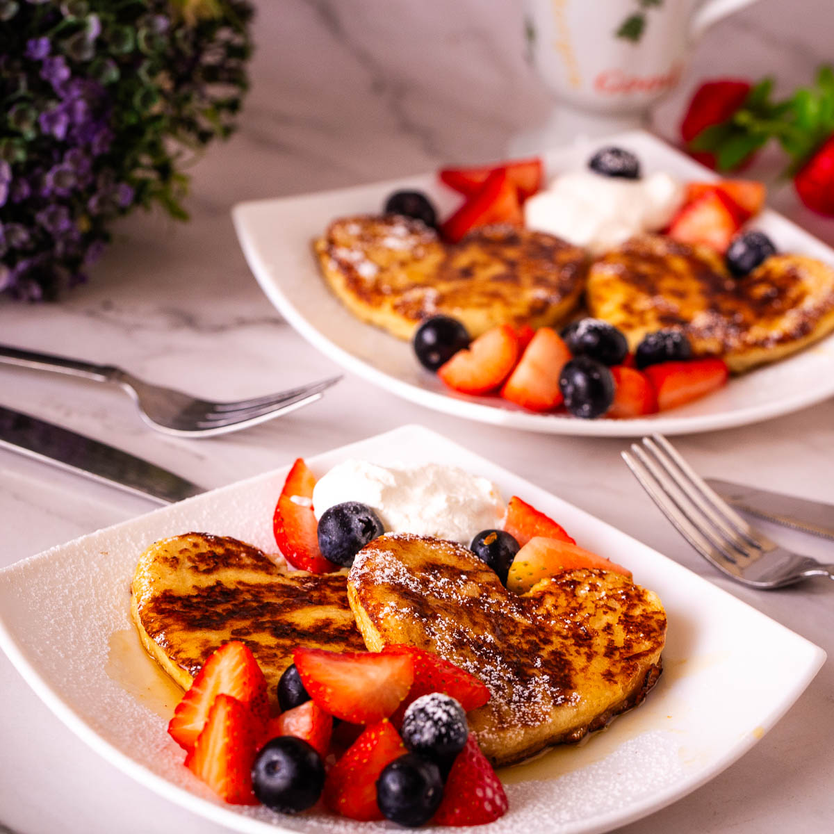 A white plate with heart-shaped French Toast.