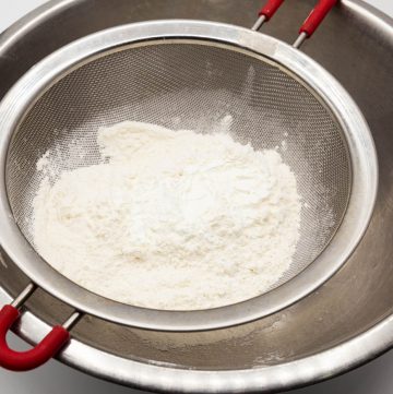 Sifting cake flour in a bowl