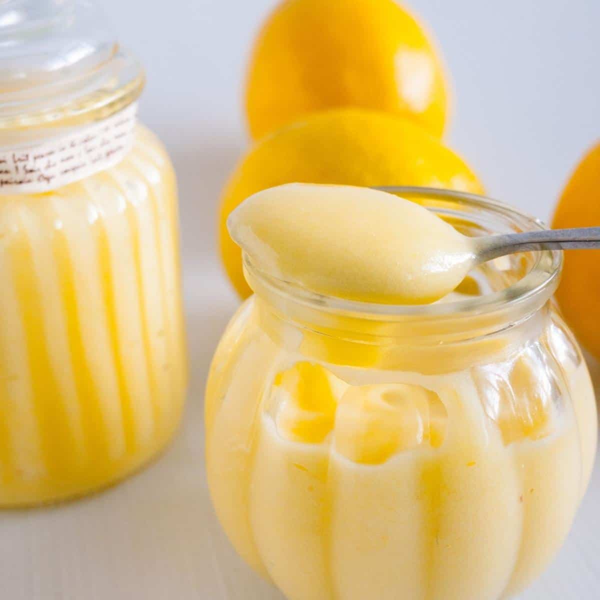 Lemon curd on a spoon in a mason jar