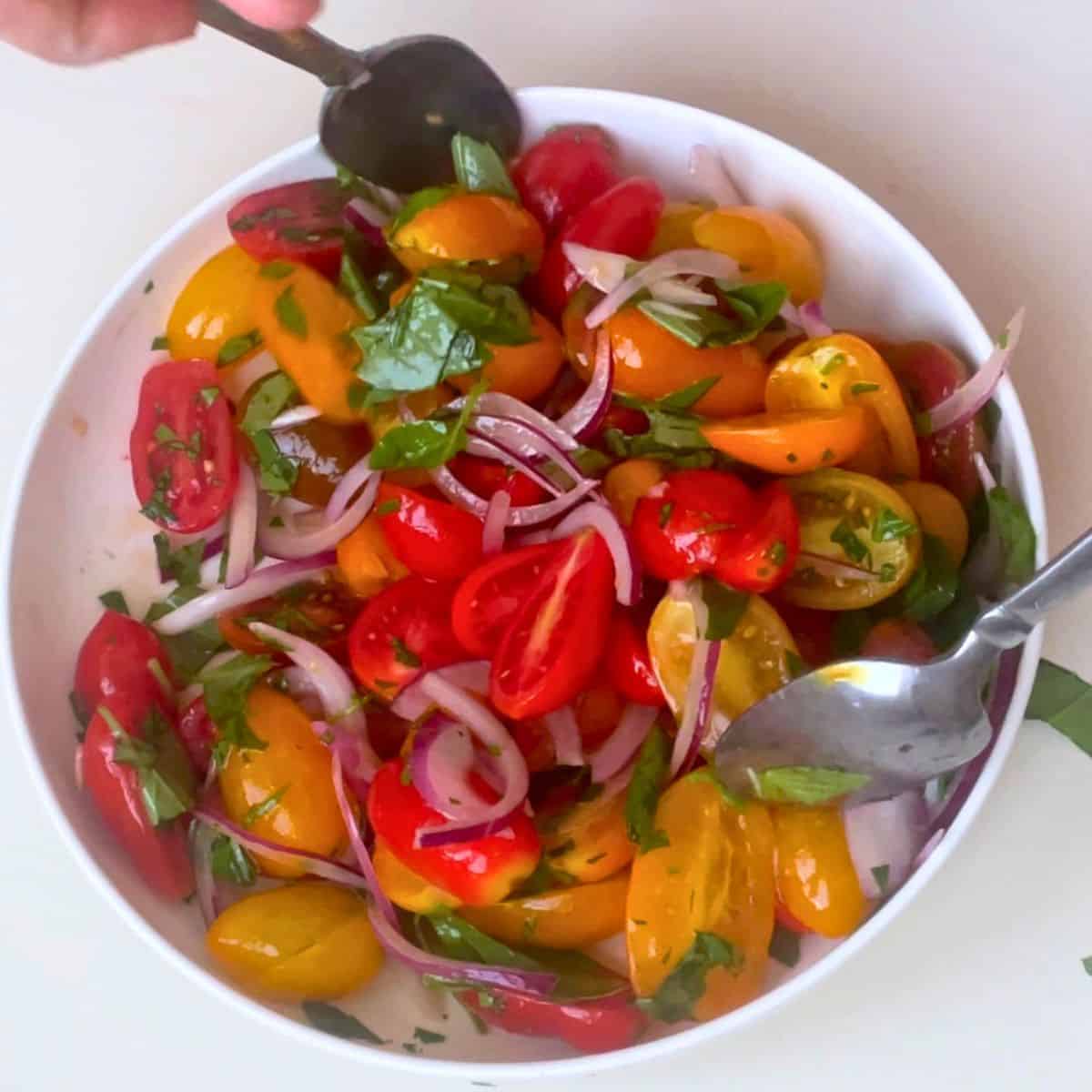 Mixing the cherry tomato salad.