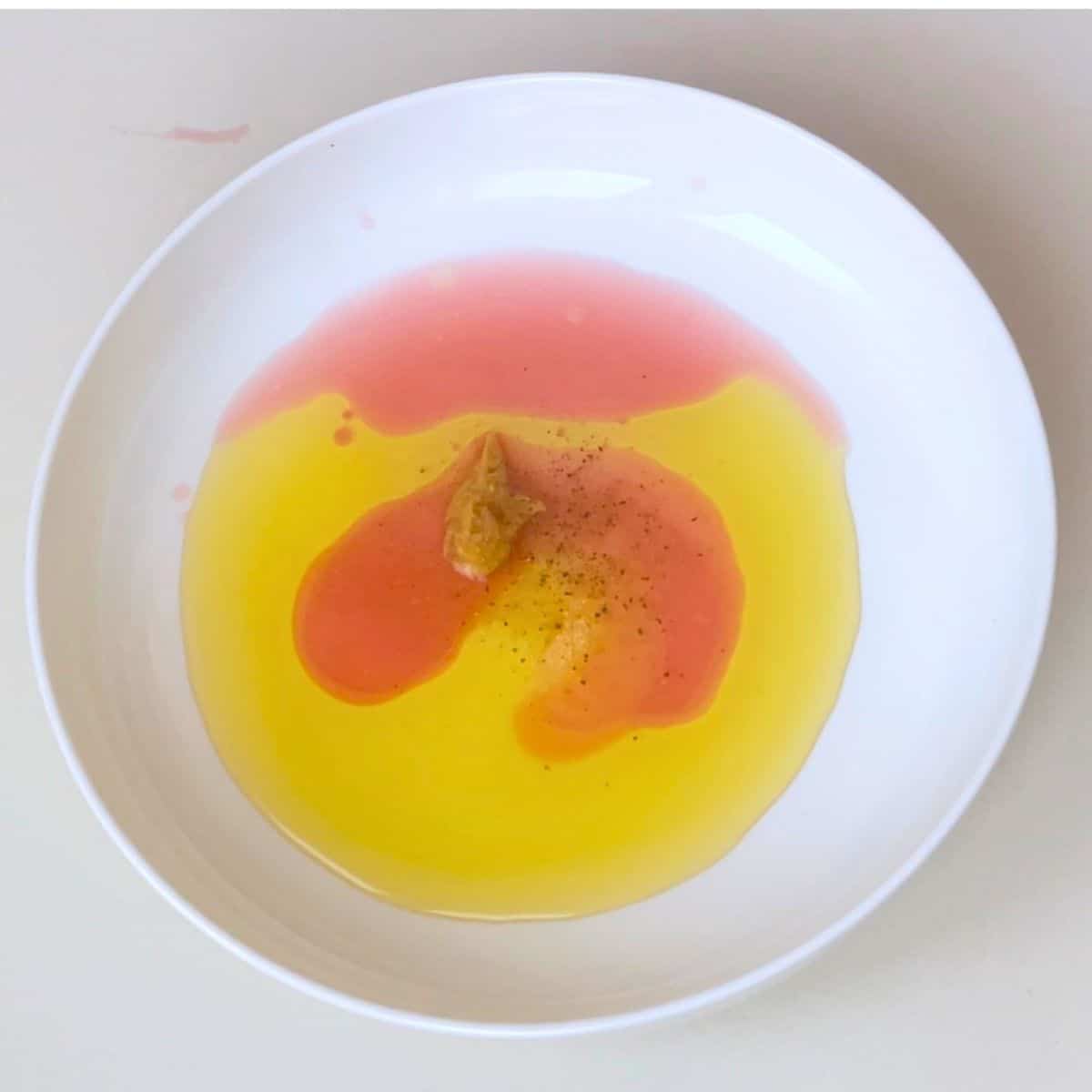 A white bowl with red wine vinaigrette.