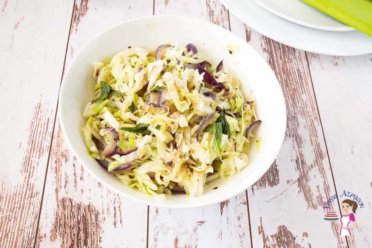 A white bowl with sauteed cabbage
