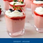 Glasses with mousse with strawberry and whipped cream.