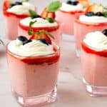 Glasses with mousse with strawberry and whipped cream.