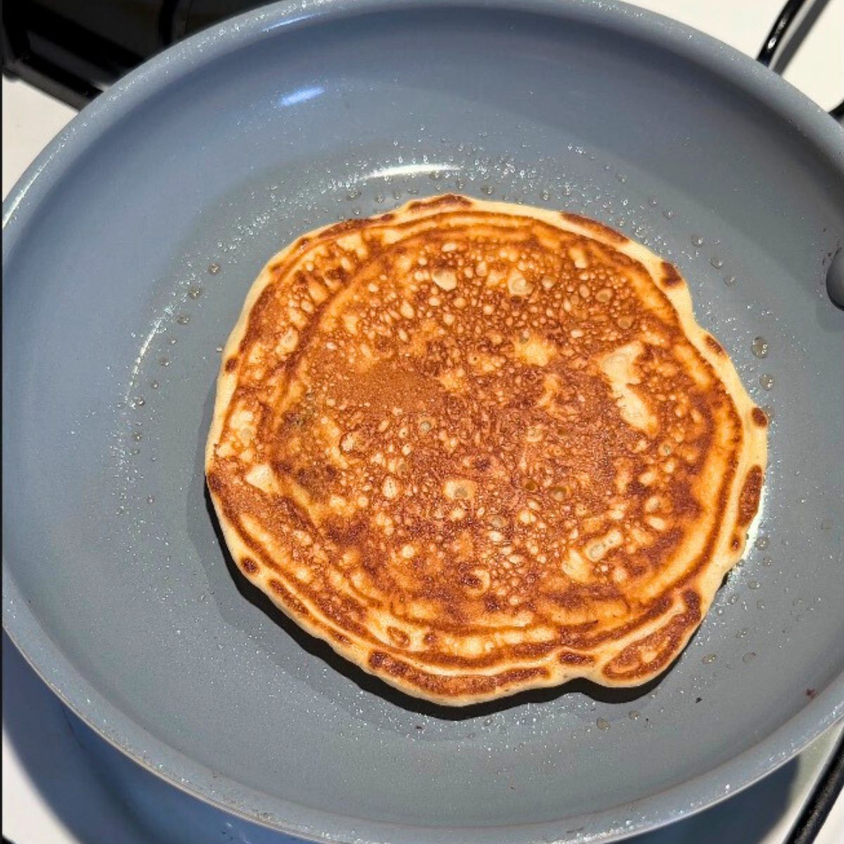 Buttermilk pancake in a frying pan.