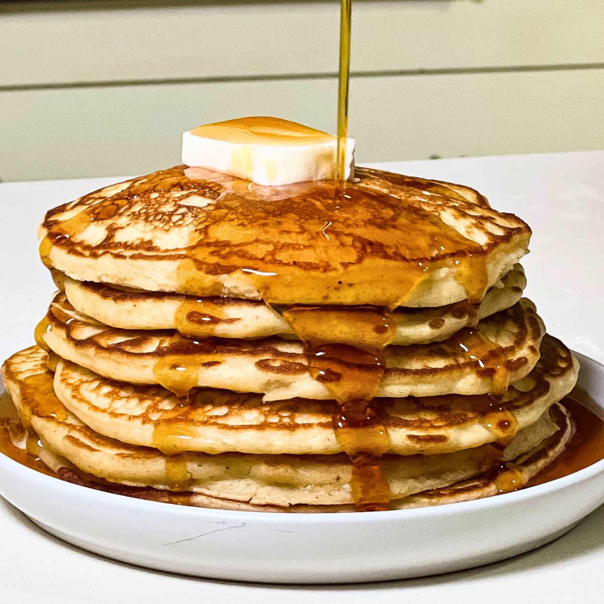 stack of homemade buttermilk pancakes with maple syrup
