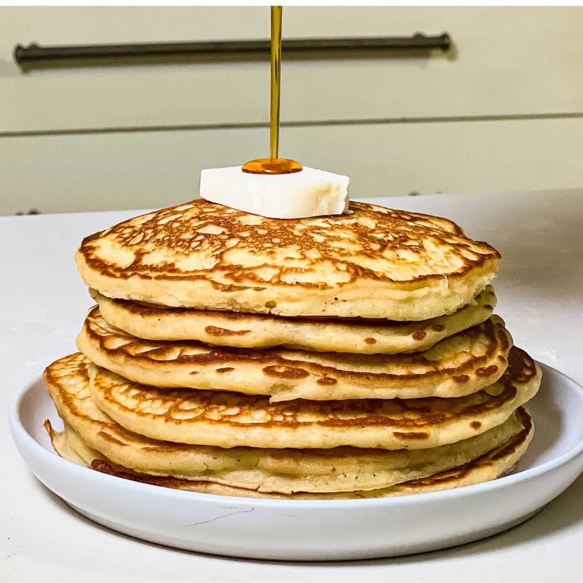 stack of homemade buttermilk pancakes with maple syrup