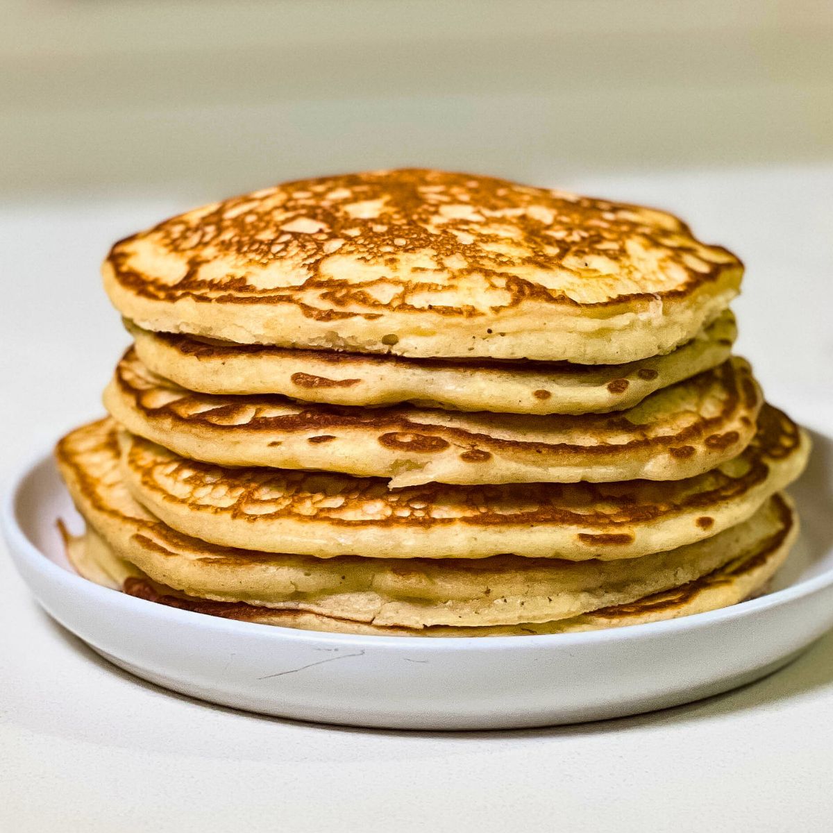 stack of homemade buttermilk pancakes with maple syrup