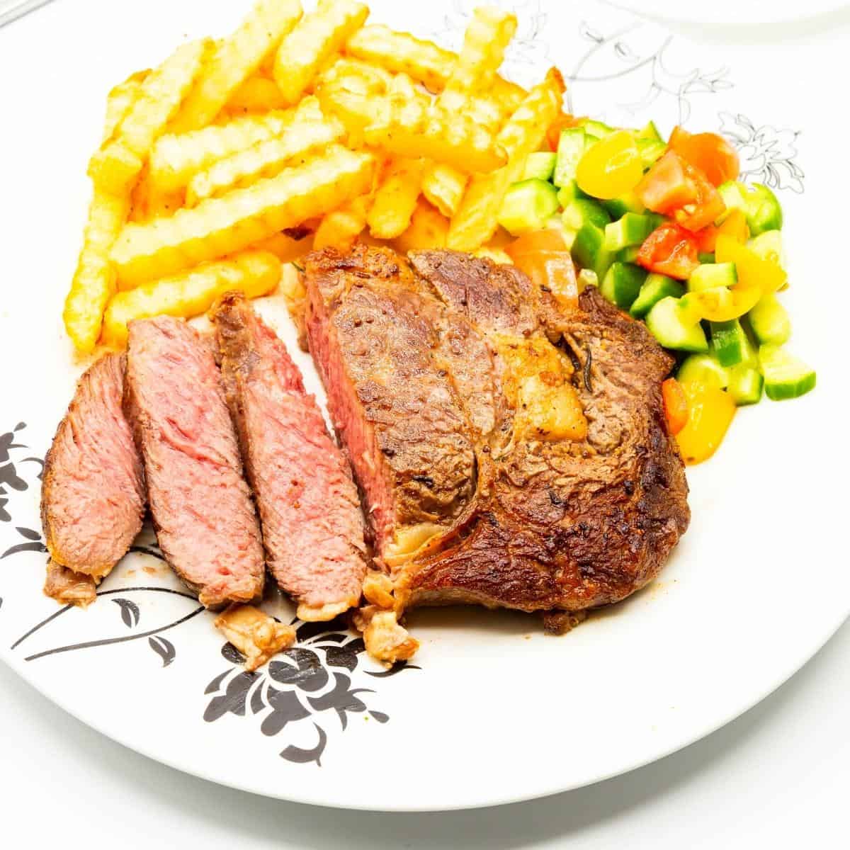 A plate with steak fries and salad.