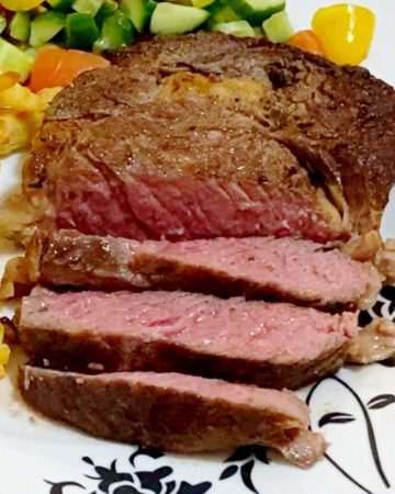 A plate with sliced medium rare steak.