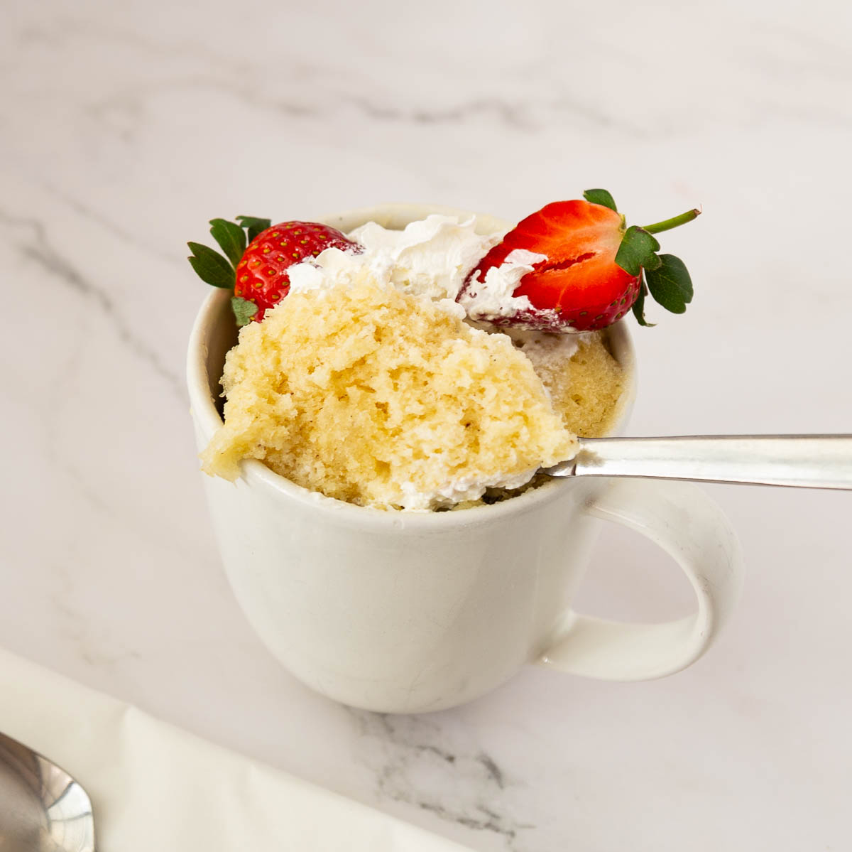 Vanilla cake in a mug with a spoon