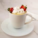 Vanilla cake in a mug topped with whipped cream