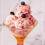 A glass with 4 scoops of strawberry no churn ice cream.