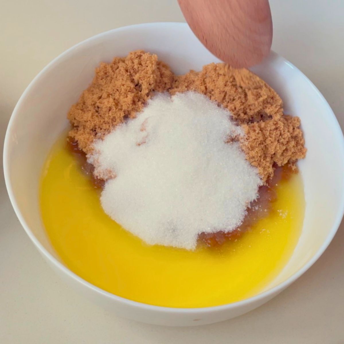 A white bowl with melted butter and sugars.
