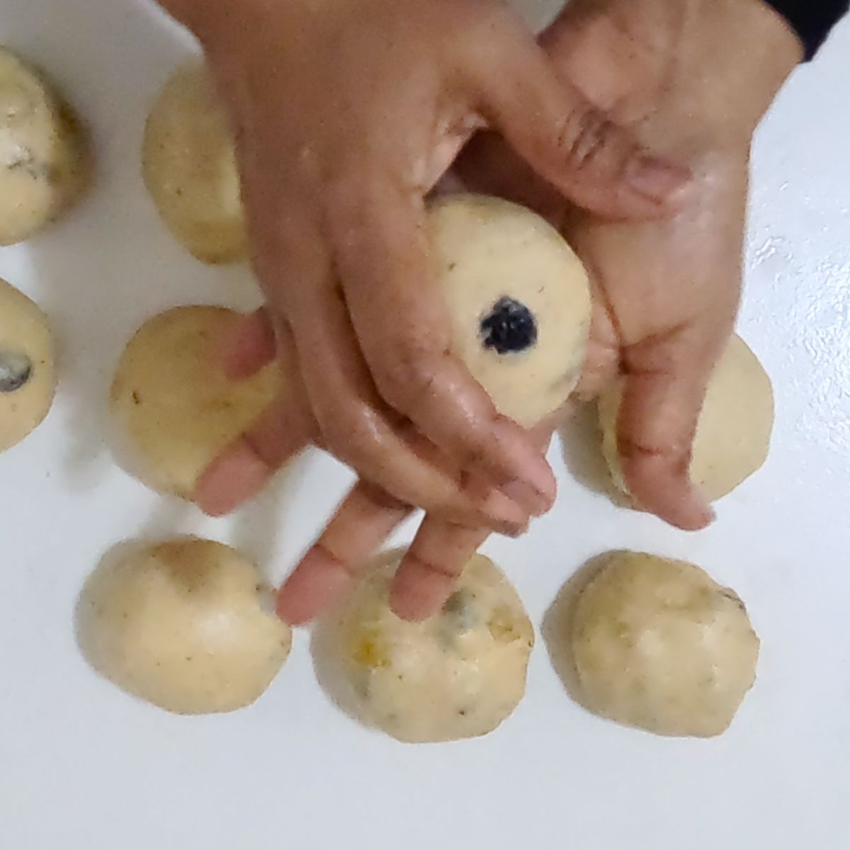 Shaping the hot cross buns with raisins.