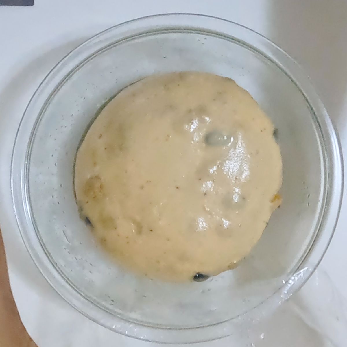 Sweet bread dough in rising in the glass bowl.