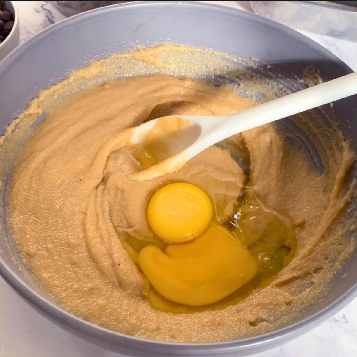Adding egg and egg yolk to butter and sugar.