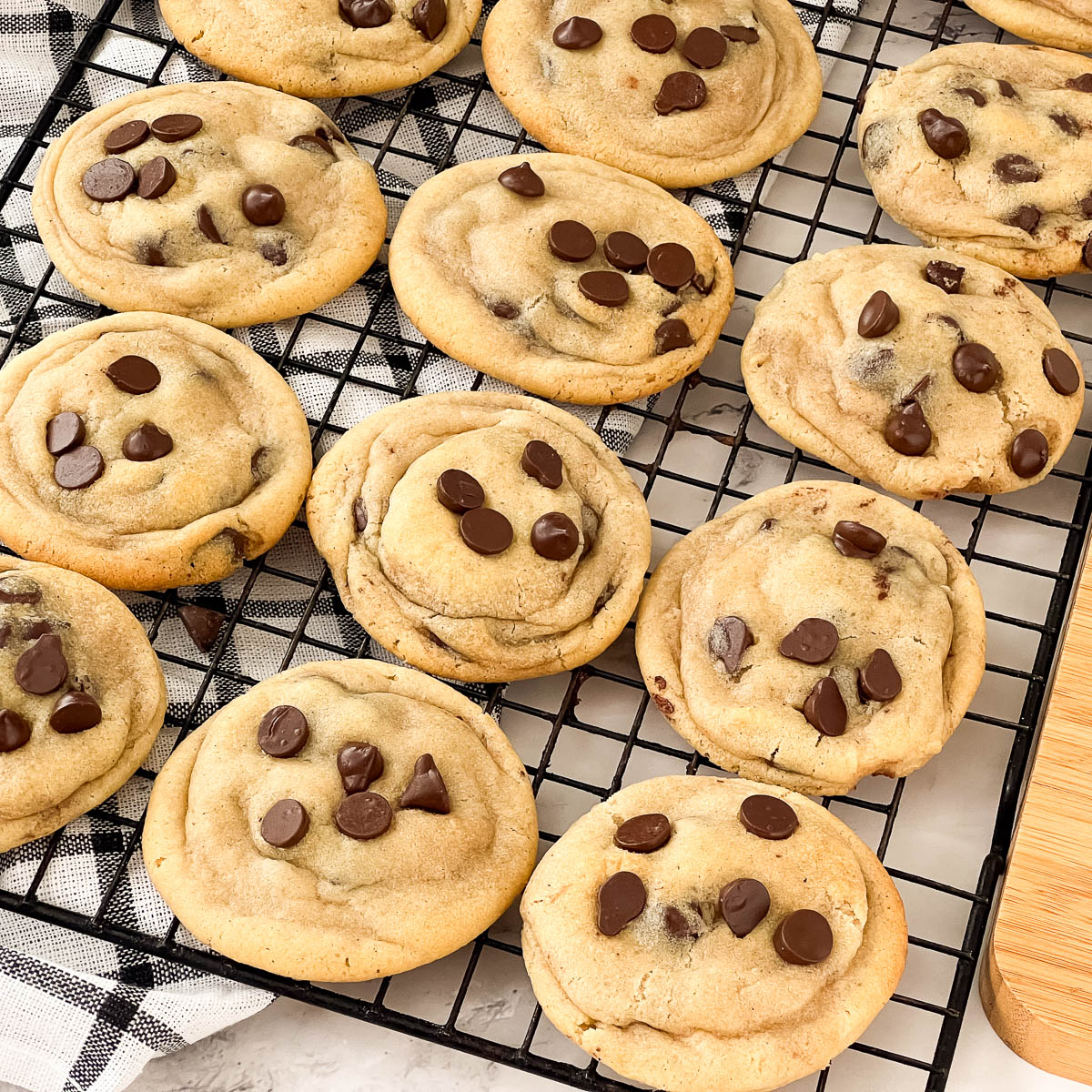 A wire rack with baked chocolate chip cookies.