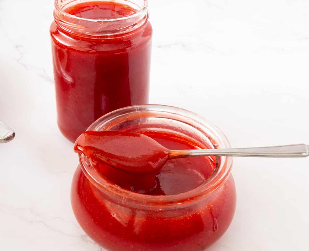 A jar with jelly made with fresh strawberries.