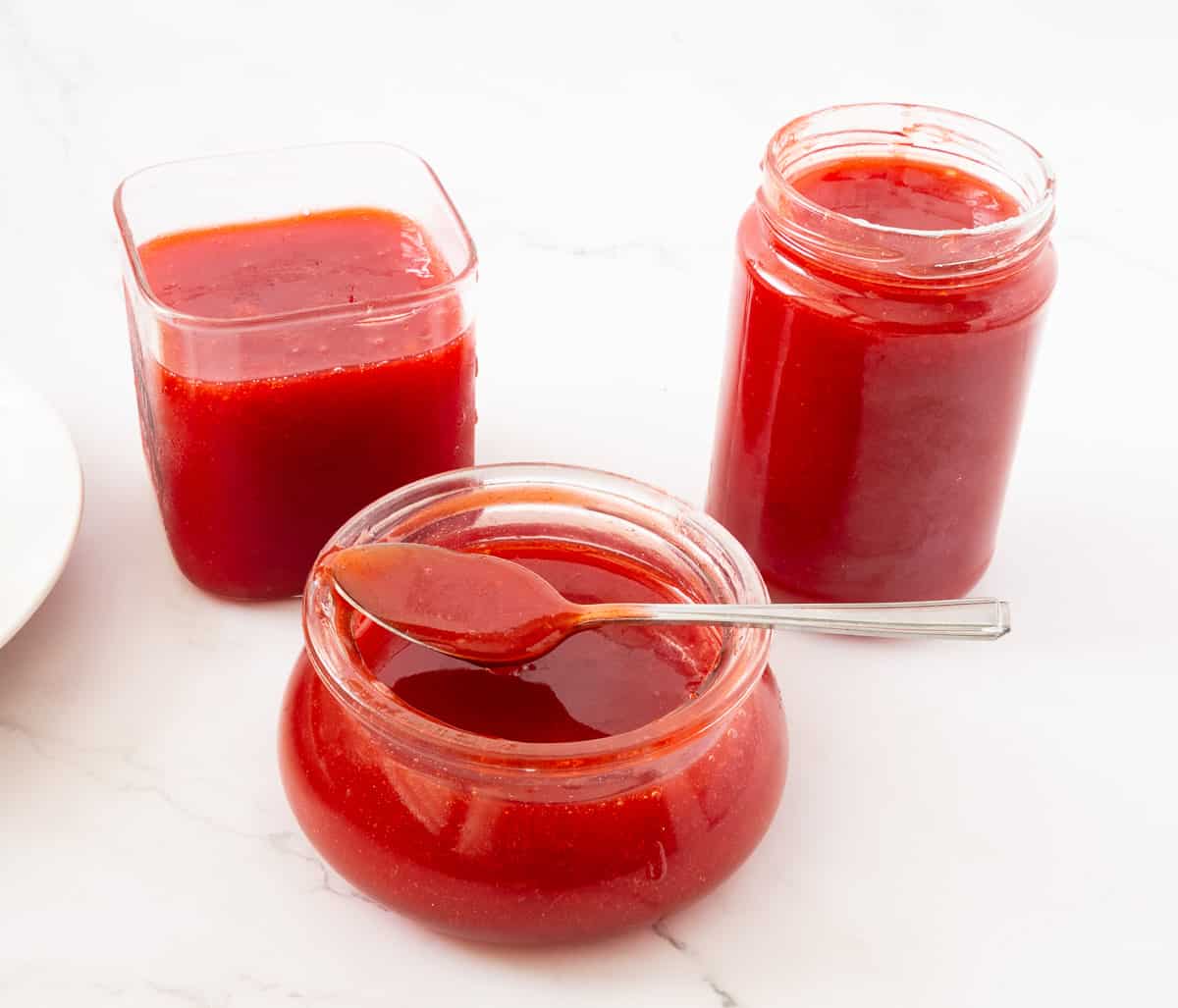 Three jars with strawberry jelly. 