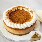 A cheesecake on a table with biscoff glaze.