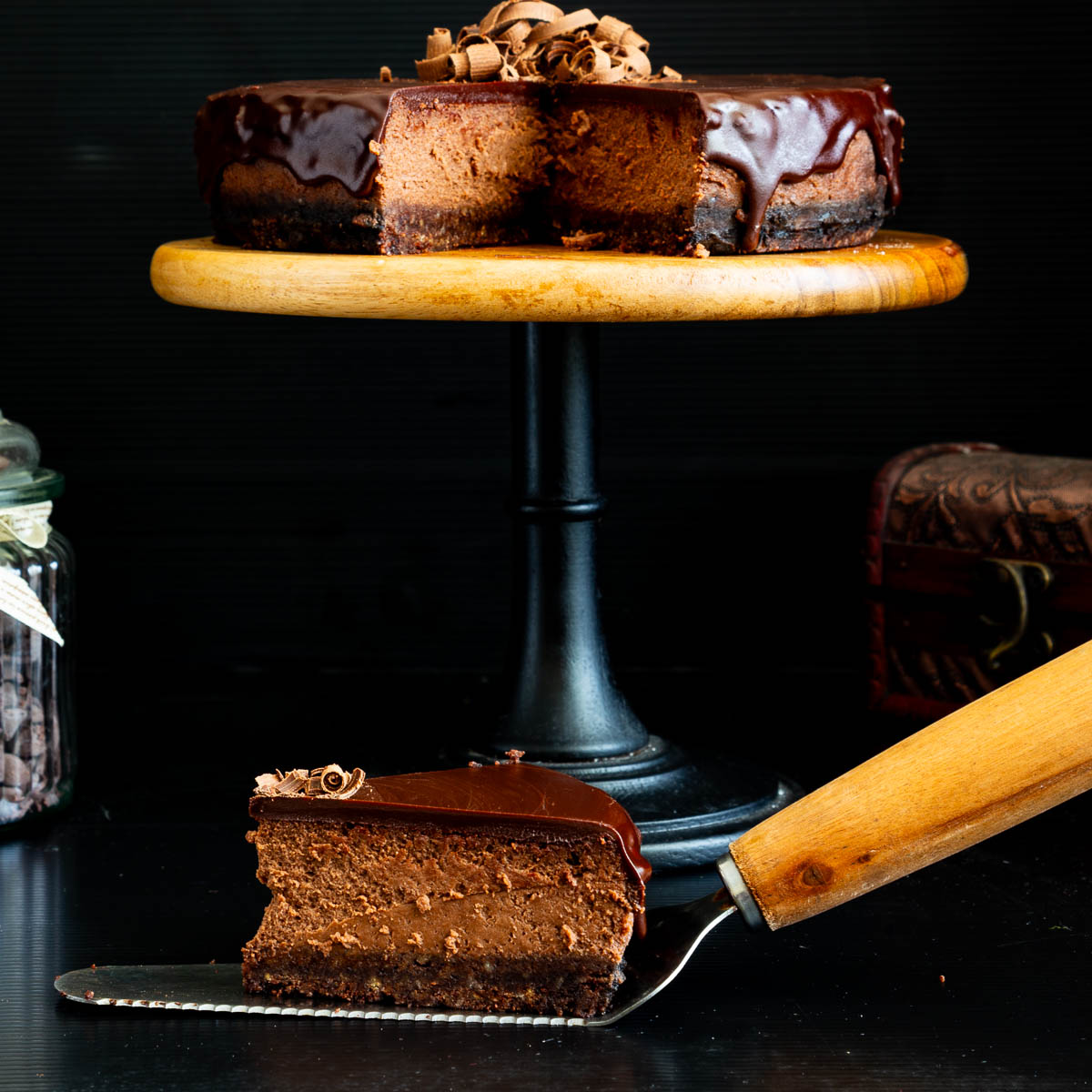 A sliced chocolate cheesecake on the cake stand.