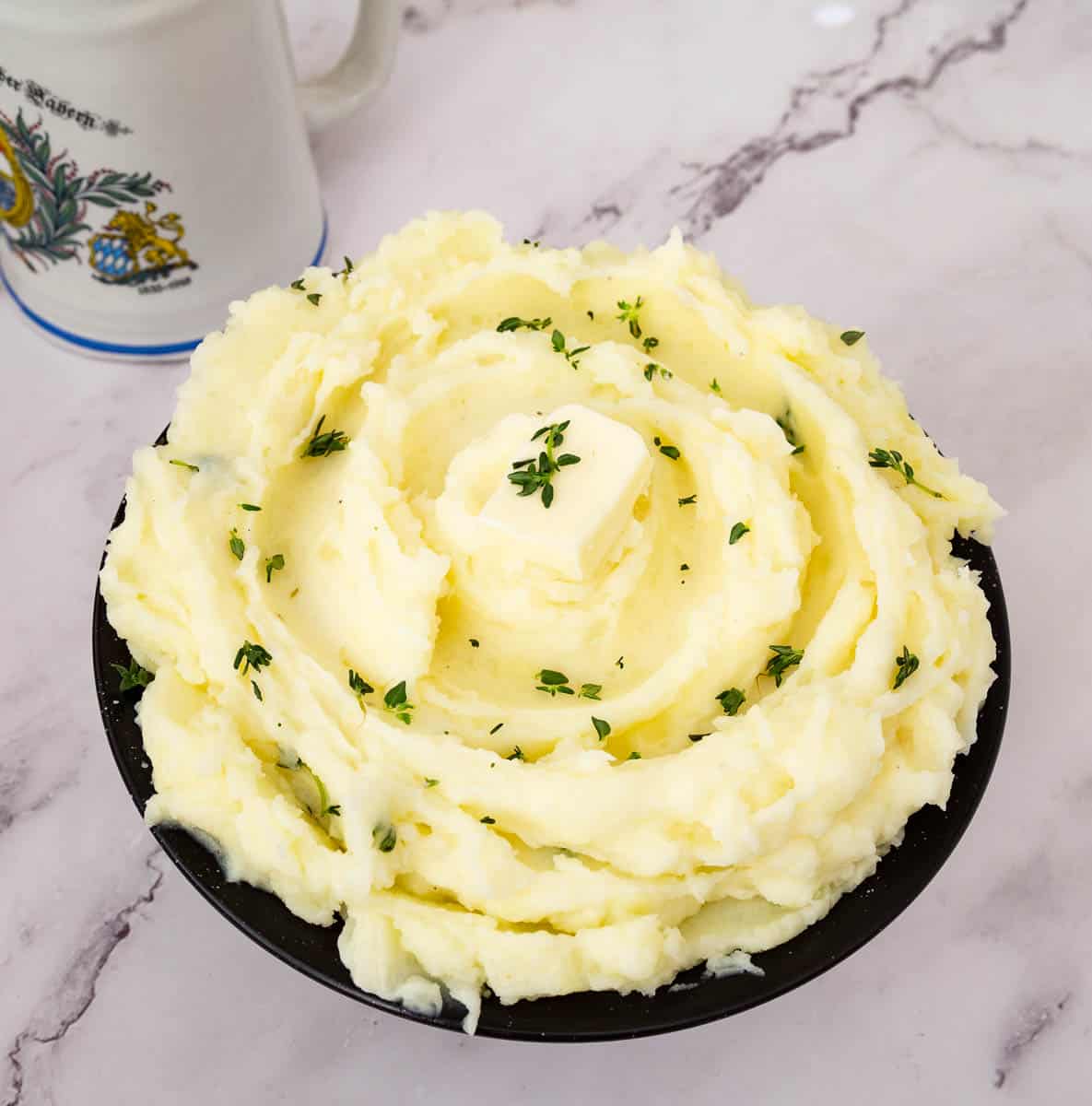 A bowl with potatoes mashed as a side dish.