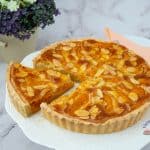 Tart with fresh apricots on a cake stand.
