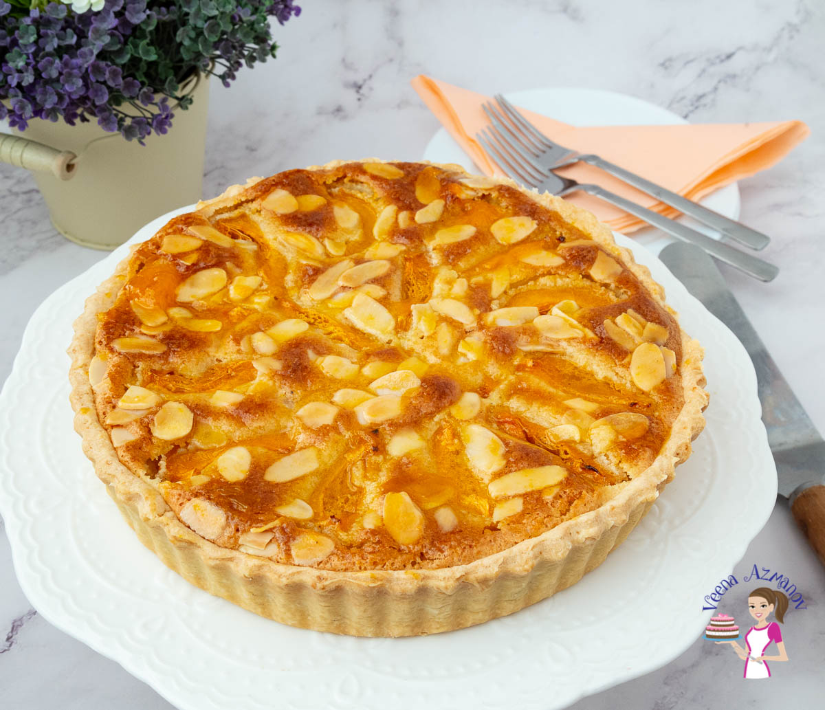 A tart with apricots on a cake stand.
