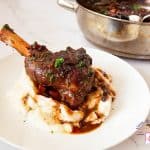 A plate with shank of lamb and red wine gravy.