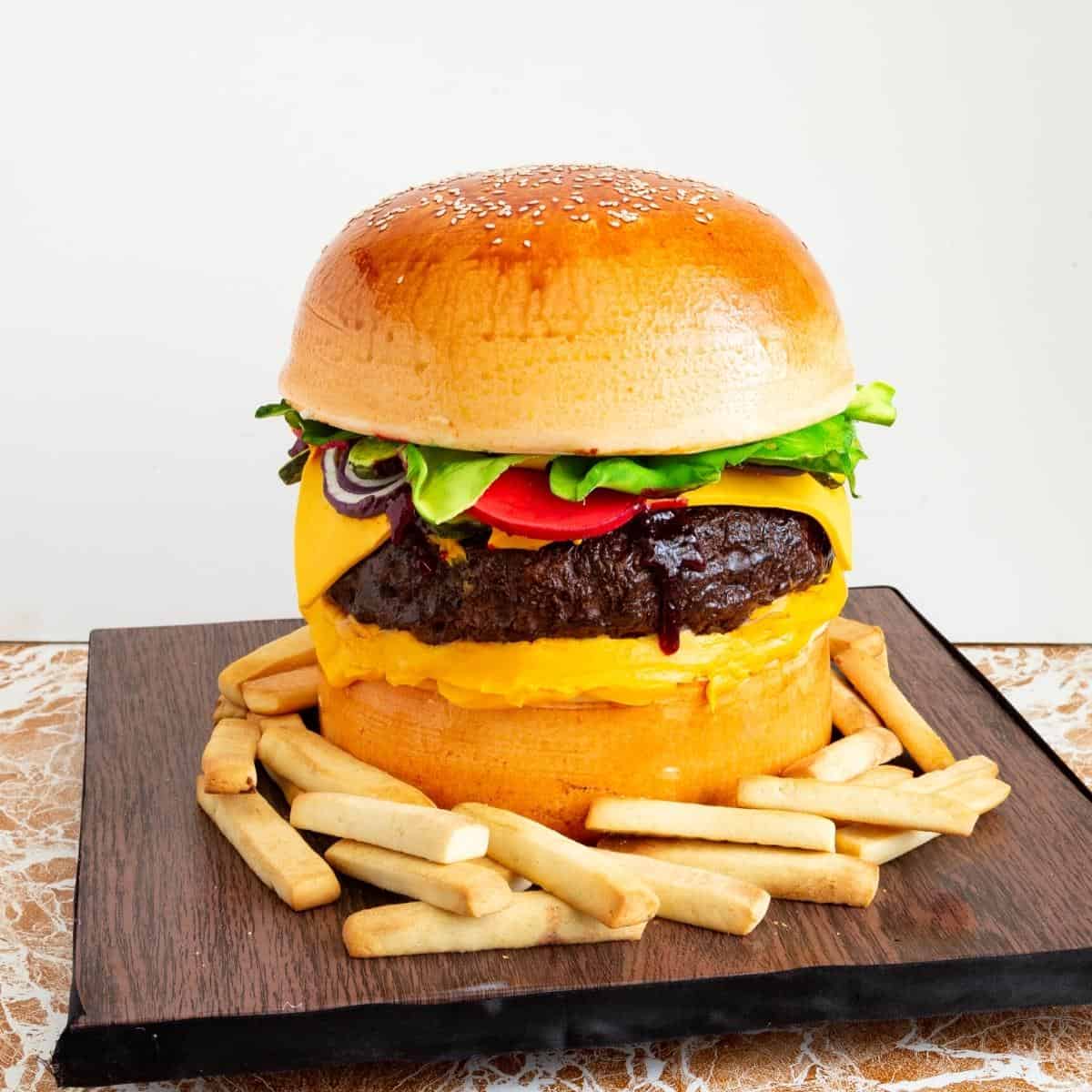 Hamburger cake on a cake board with cookie French fries.