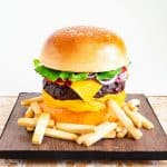 Hamburger cake on a cake board with French fries.