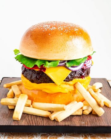 Hamburger cake on a cake board with French fries.