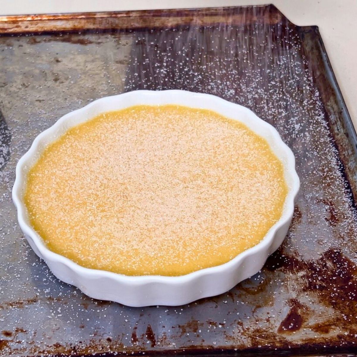 A ramekin with caster sugar dusted on the top surface.