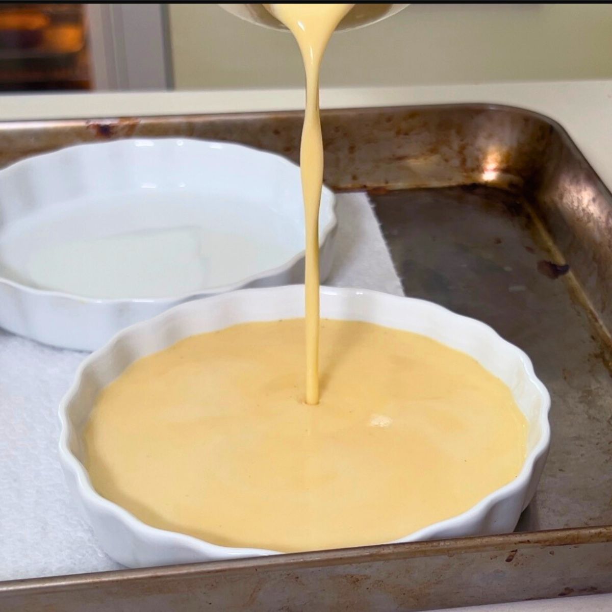 Progress pictures pouring crème brûlée mixture into ramekins.