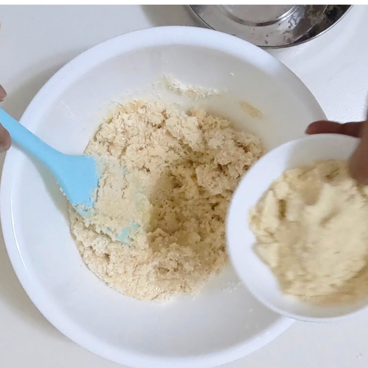 Adding ground almonds to make macaroons.