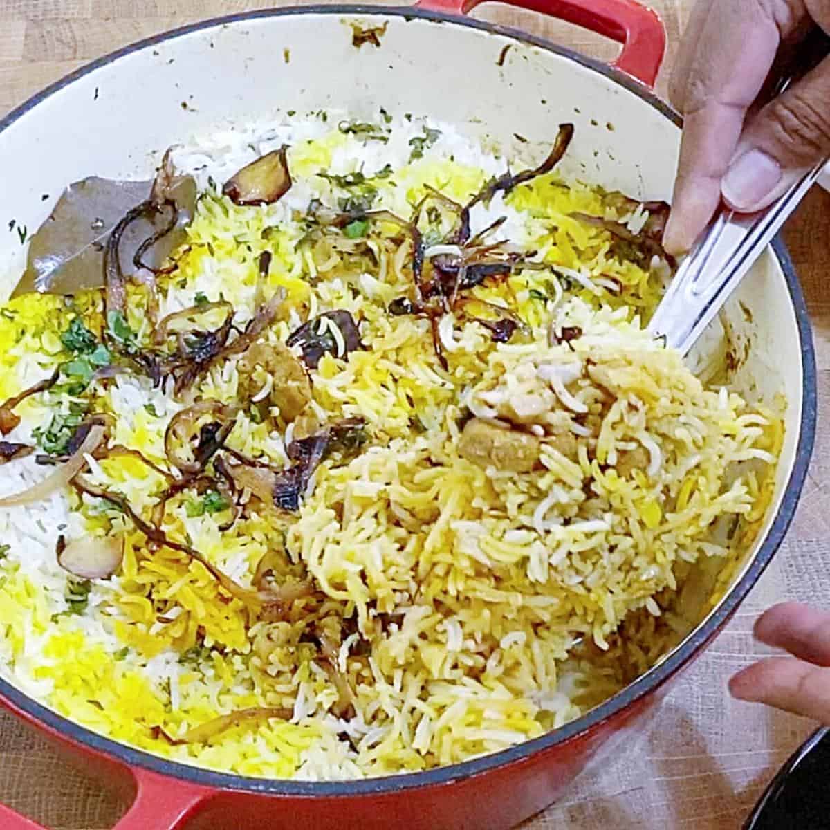 A Dutch oven with biryani made with chicken.