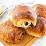Stack of Chocolate Croissants on a wooden board.