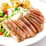 A plate with pan seared ahi tuna steak.