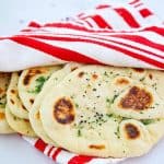 Garlic naan wrapped in clean kitchen cloth.